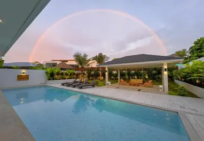 a rainbow over a swimming pool with a house at Bangtao Luxury Pool Villa - PrymaSelva in Laguna Phuket