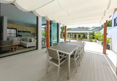 an open deck with a wooden table and chairs at Bangtao Luxury Pool Villa - PrymaSelva in Laguna Phuket