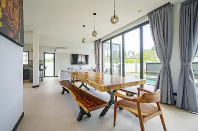 a dining room with a wooden table and chairs at Camellia Pool VillaNear Nai Harn And Rawai Beach in Ban Saiyuan (1)