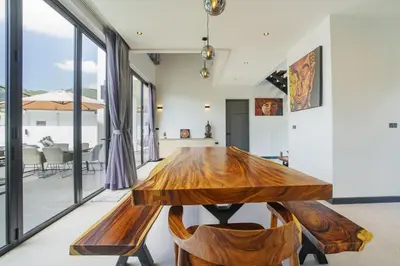 a dining room with a wooden table and chairs at Camellia Pool VillaNear Nai Harn And Rawai Beach in Ban Saiyuan (1)