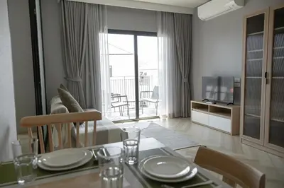 a living room with a dining table and a living room with a television at The Legendary Bang Tao 1-bedroom apart #711 in Bang Tao Beach