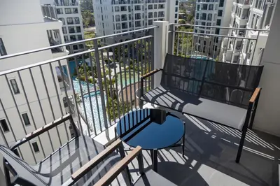 a balcony with two chairs and a blue table at The Legendary Bang Tao 1-bedroom apart #711 in Bang Tao Beach