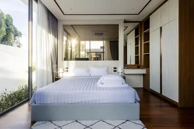 a bedroom with a large bed and a large window at Villa The Ozone in Ban Thalat Choeng Thale