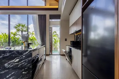 a kitchen with black granite counter tops and a large window at Villa The Ozone in Ban Thalat Choeng Thale