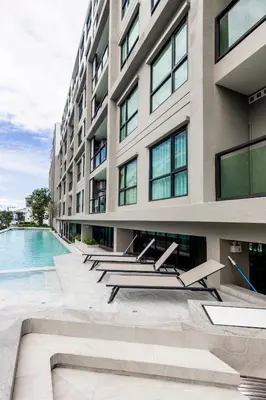 an exterior view of a building with a swimming pool at The SPACE Apartment 614 in Ban Thalat Choeng Thale