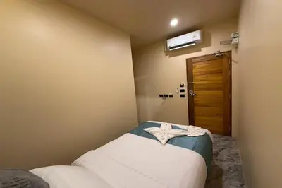 a small bedroom with a bed and a door at Sand Maré Karon Hotel in Karon Beach