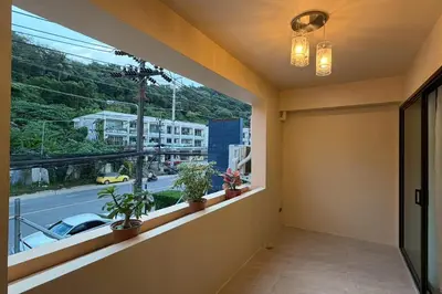 a balcony with plants and a view of a street at Sand Maré Karon Hotel in Karon Beach
