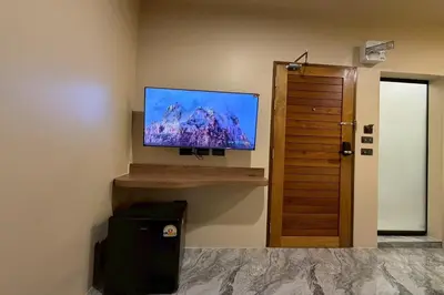a flat screen tv on a wall in a room at Sand Maré Karon Hotel in Karon Beach