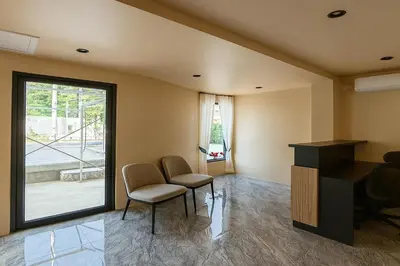 a room with two chairs and a table and a window at Sand Maré Karon Hotel in Karon Beach