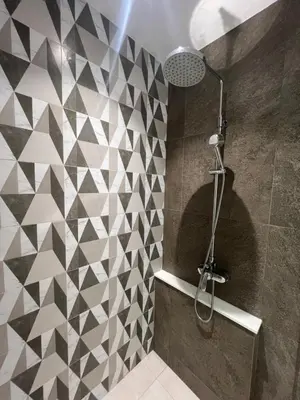 a shower stall in a bathroom with a tiled wall at Sun Sea Sand in Thalang