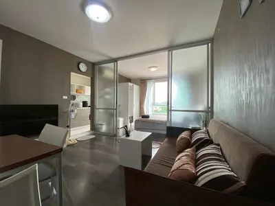 a living room with a couch and a large window at Nassaree Condo in Phuket Town