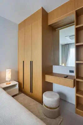 a bedroom with a bed with a mirror and a stool at Botanica Four Seasons Bang Tao by My Home Phuket in Ban Na Sok