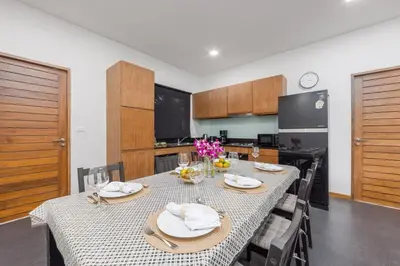 a dining room with a table and a kitchen at Villa Kiana 2BR Private Pool 10 min to Nai Harn in Ban Saiyuan (1)
