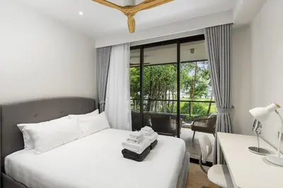 a bedroom with a bed and a desk and a window at Laguna BeachSide Bang Tao by My Home Phuket in Bang Tao Beach