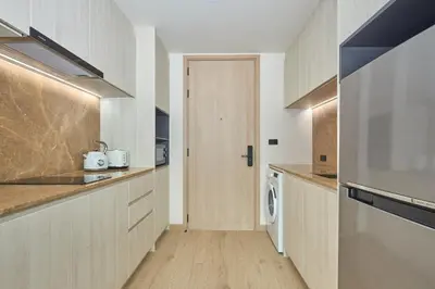 a kitchen with a washer and dryer next to a door at Ozone condominium Bang Tao by My Home Phuket in Laguna Phuket