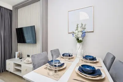 a dining room with a table and chairs and a tv at Ozone condominium Bang Tao by My Home Phuket in Laguna Phuket