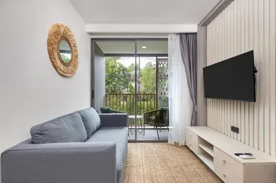 a living room with a blue couch and a television at Ozone condominium Bang Tao by My Home Phuket in Laguna Phuket