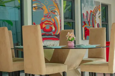 a dining room with a table and chairs with a painting at Villa Heaven - Peaceful 3 Bedroom Private Pool Villa in Ban Kata