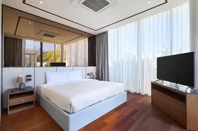 a bedroom with a bed and a flat screen tv at Villa the Ozone Bang Tao by My Home Phuket in Laguna Phuket