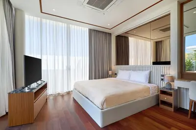 a hotel room with a bed and a television at Villa the Ozone Bang Tao by My Home Phuket in Laguna Phuket