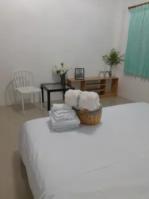 a room with a bed with a basket of towels at Baan Saun PK in Ban Bang La