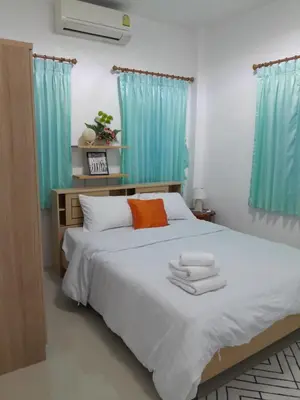 a bedroom with a bed with two towels on it at Baan Saun PK in Ban Bang La