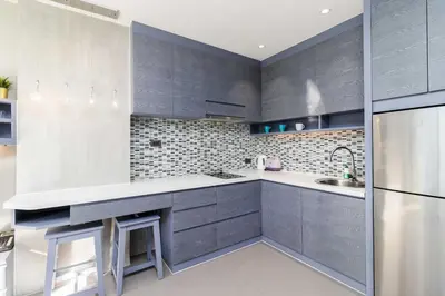 a kitchen with gray cabinets and a refrigerator at C255 Best Stay Experience Condo with Full Facilities in Kamala Beach