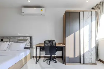 a bedroom with a bed and a desk with a chair at V274 Prime Location Large Terrace Pool View BBQ in Ban Saiyuan (1)