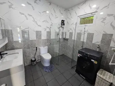 a bathroom with a toilet and a washing machine at 2 Bedrooms Tropical Pool Villa Rawai in Rawai Beach