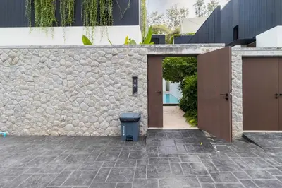 a stone wall with a trash can in a courtyard at V275 Stay with Nature 2BR Peaceful Pool Villa in Ban Pak Lak