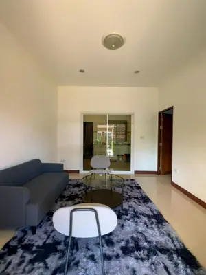 a living room with a couch and a table and chairs at Sea sand Bungalow in Phuket Town