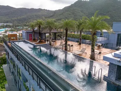 a swimming pool on top of a building with palm trees at Comfortable 1 bdr Kamala City Gate in Kamala Beach