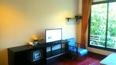 a room with a desk with a computer and a window at Baan-kawkaew-kata in Karon Beach