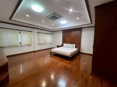 a bedroom with a bed and a wooden floor at Villa Vasu in Ban Bang Khu