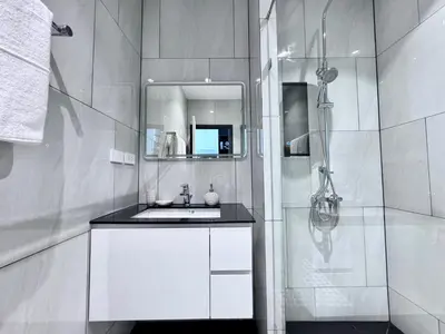 a white bathroom with a sink and a shower at Title Ledgendary 7th Floor in Bang Tao Beach