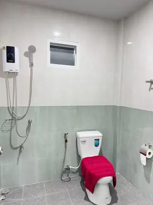 a bathroom with a toilet with a red cover at Karon Little House in Karon Beach