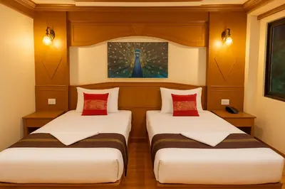 two beds in a room with a painting on the wall at Tiger Complex Inn in Patong Beach