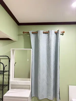 a bathroom with a shower curtain and a mirror at Milos House in Phuket Town