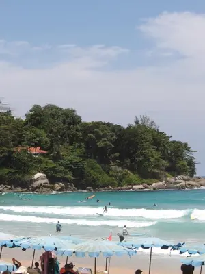 a group of people on a beach with the ocean at Milos House in Phuket Town