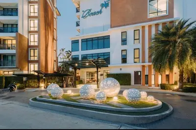 a large building with a sculpture in front of it at The Beach Condotel Kata in Kata Beach