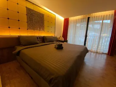 a bedroom with a bed with a teddy bear on it at The Beach Condotel Kata in Kata Beach
