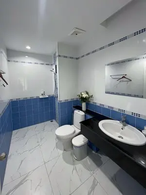 a blue and white bathroom with a toilet and a sink at Green place condominium in Ban Lo Long