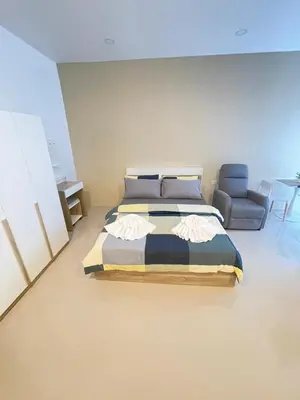 a bedroom with a bed and a chair at Nai-harn Apartments in Phuket Town