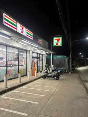 a motorcycle parked at a gas station at night at Milos House in Ban Kata