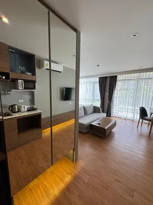 a living room with a couch and a table at Apartment Naithon Wyndham in Nai Thon Beach