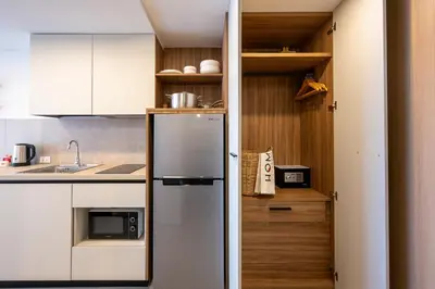 a kitchen with a stainless steel refrigerator and wooden cabinets at HOMA Chalong Bay in Ban Klang