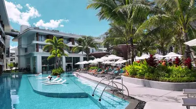 a pool at a resort with people laying on chairs and umbrellas at Beachfront 1 Bedroom 361 Condo Kora Resort in Phuket Town