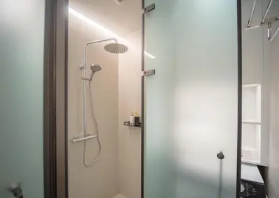 a shower with a glass door in a bathroom at Kora Beachfront 240 One Bedroom Apartment Phuket in Phuket Town
