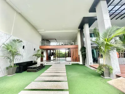a house with a green lawn in front of it at Modern 1 Bedroom Apartment - At The Tree Rawai in Rawai Beach
