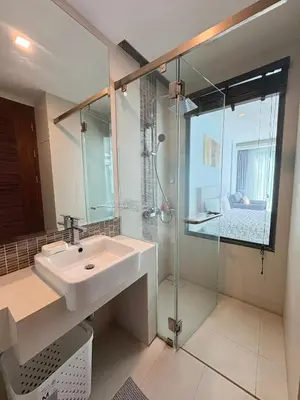 a bathroom with a sink and a glass shower at Modern 1 Bedroom Apartment - At The Tree Rawai in Rawai Beach